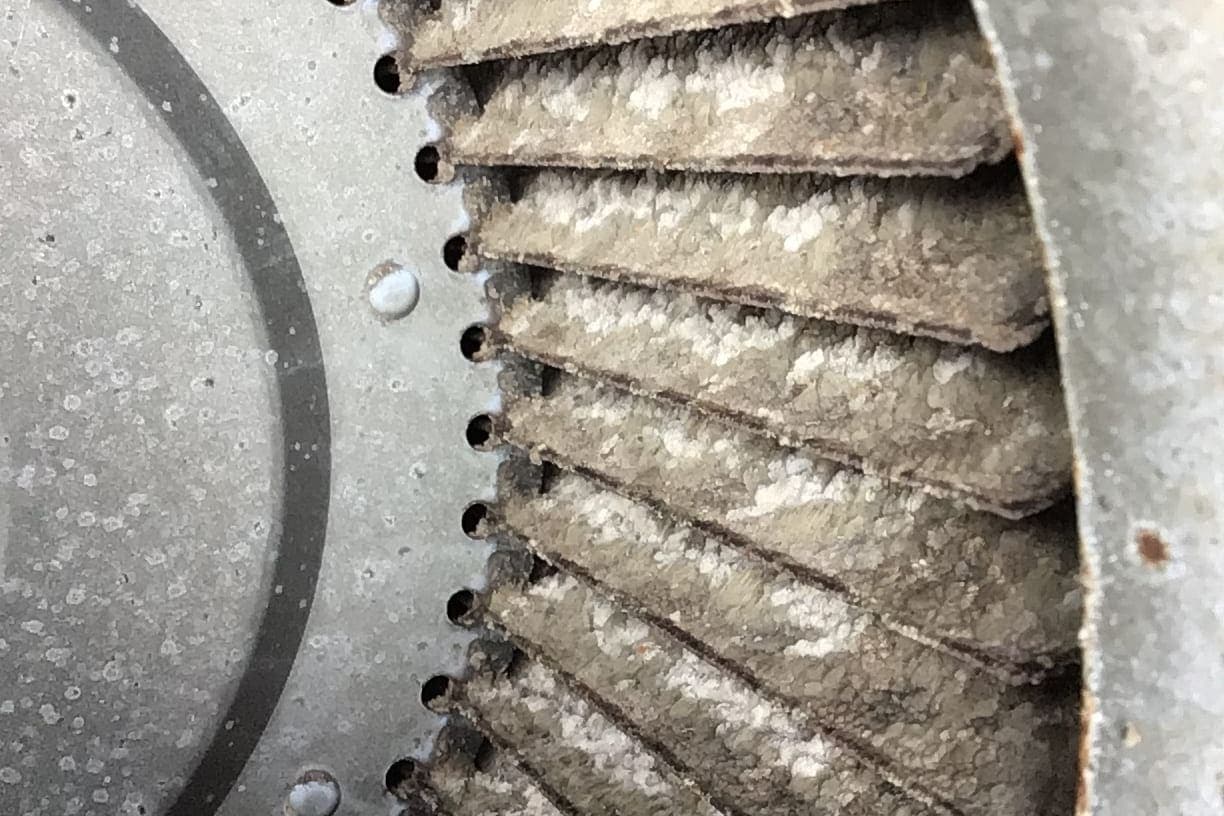 A blower wheel caked in dust.