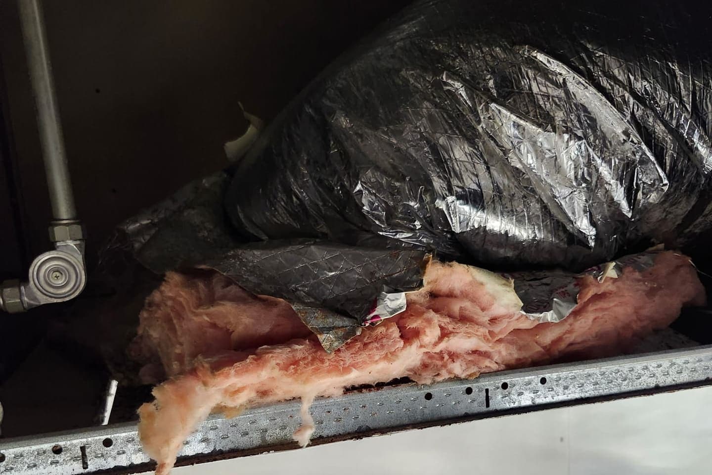 Fiberglass insulation inside a duct plenum.