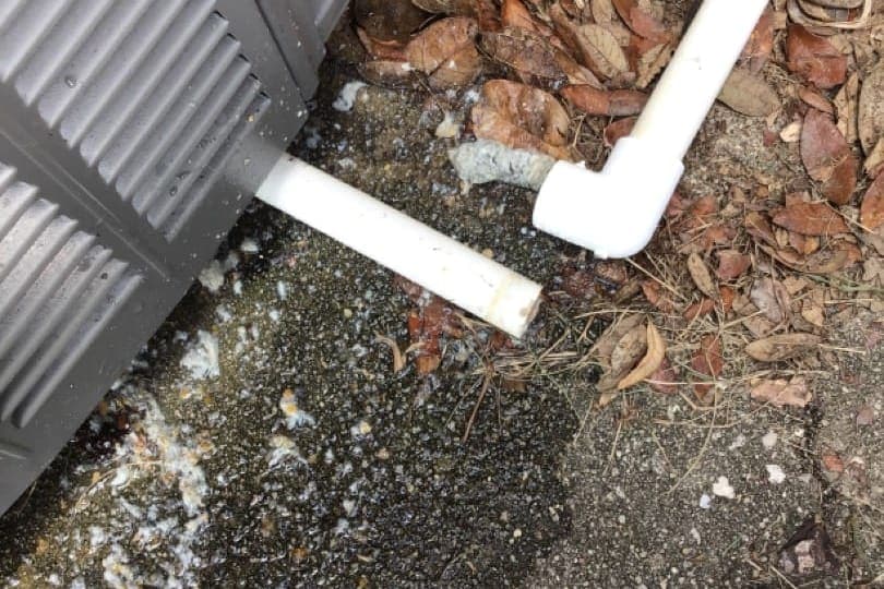 A PVC condensate drain line leaving the house.