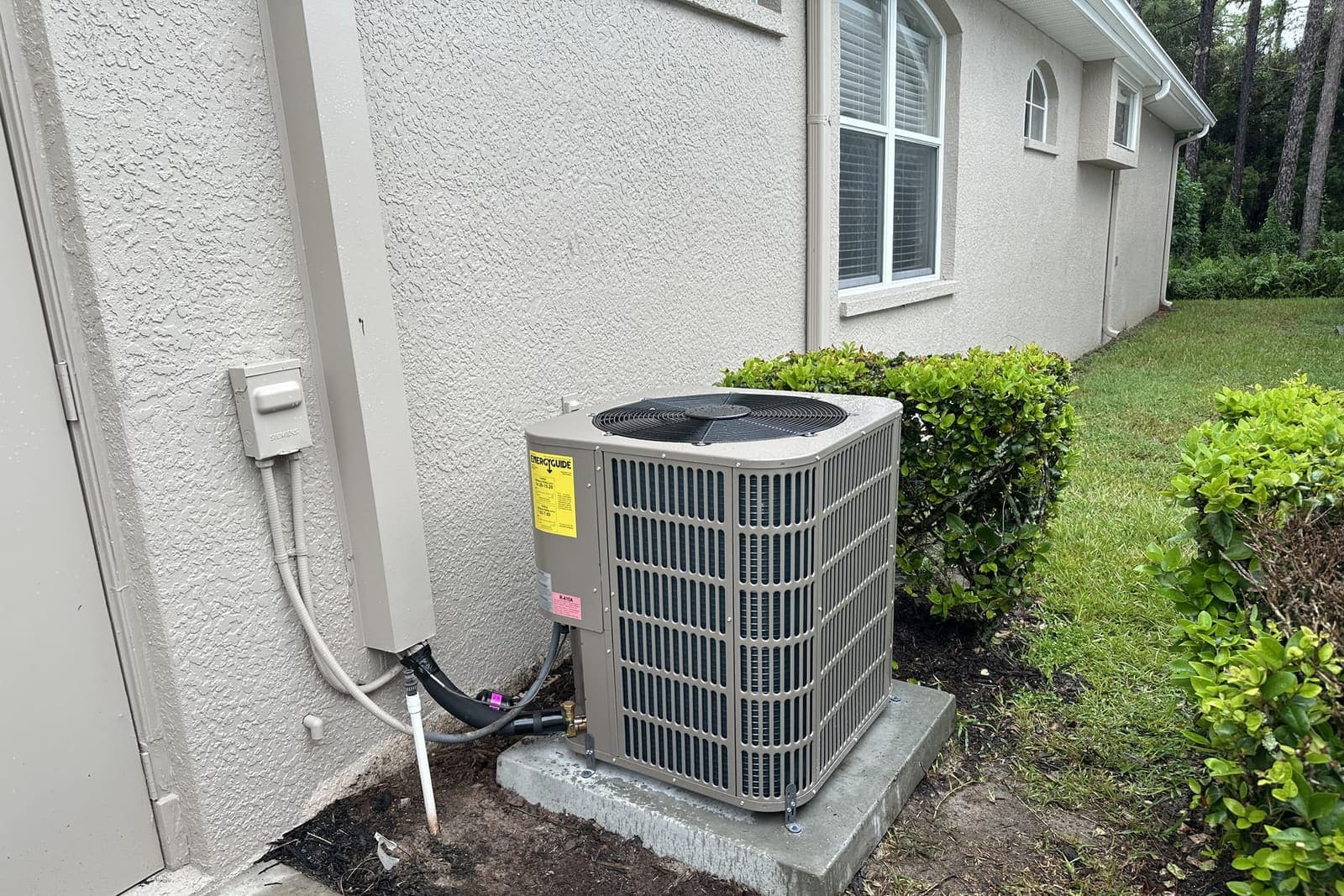 An outdoor condenser on a concrete pad beside a house in Hernando County, FL.