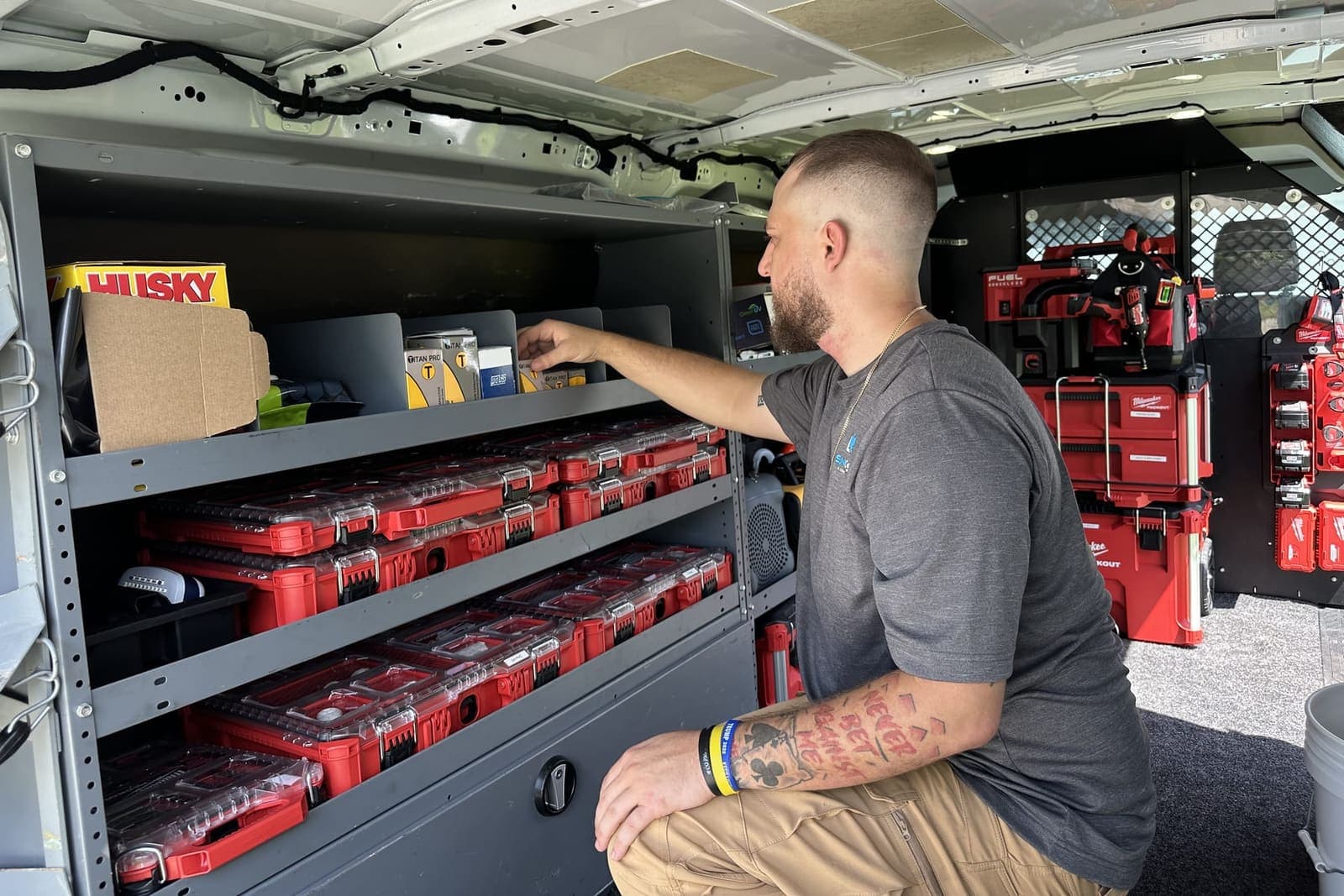 A SunCoast technician reaching for parts on the shelves inside the van in Spring Hill, FL.