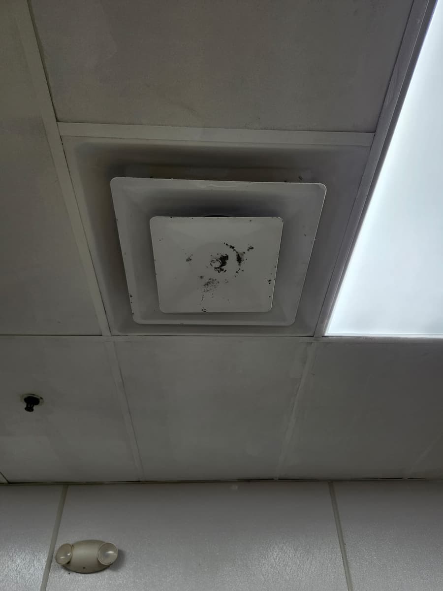 A ceiling supply vent with dust stains around it.