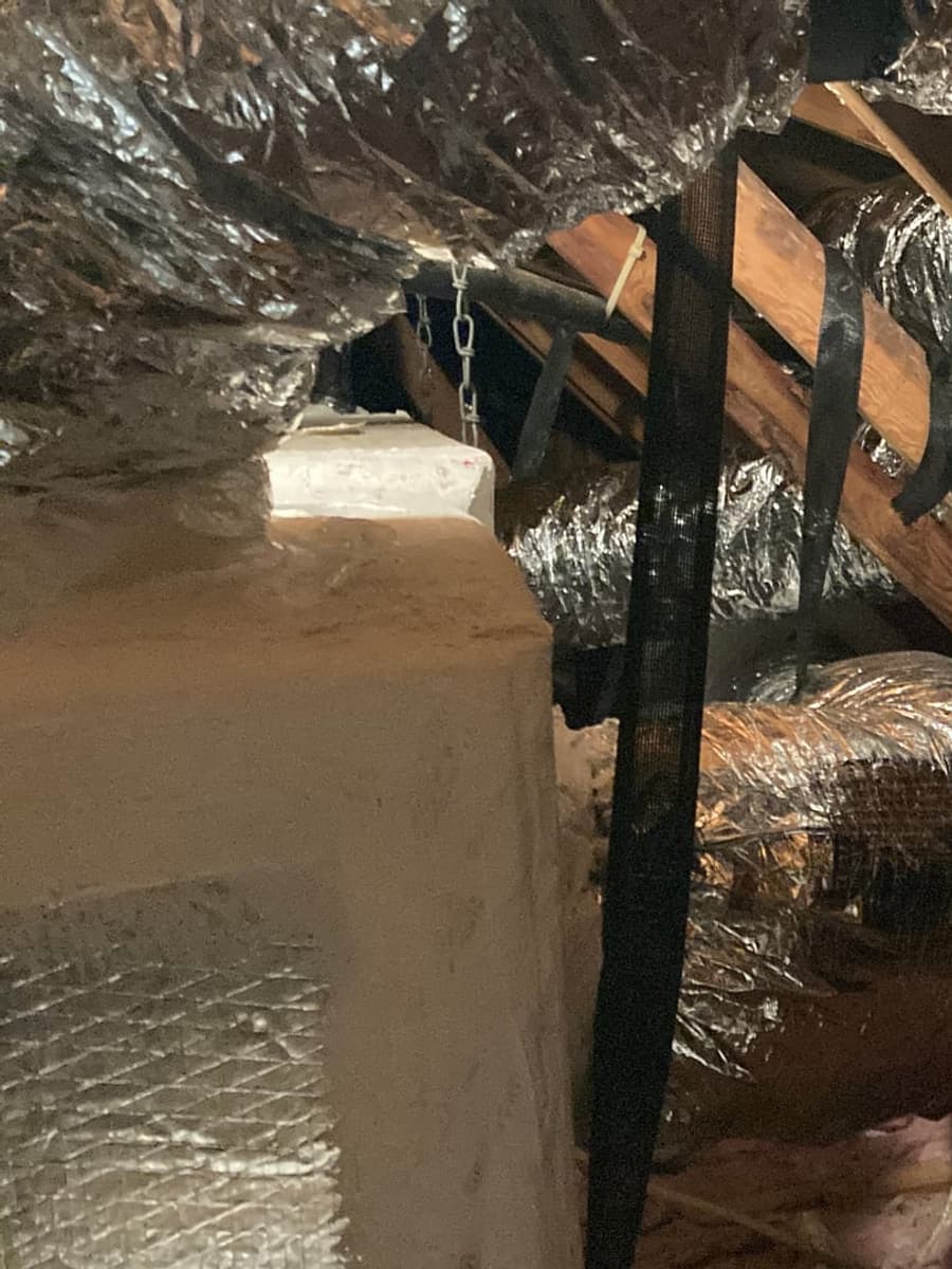 Flexible duct runs crossing attic rafters.