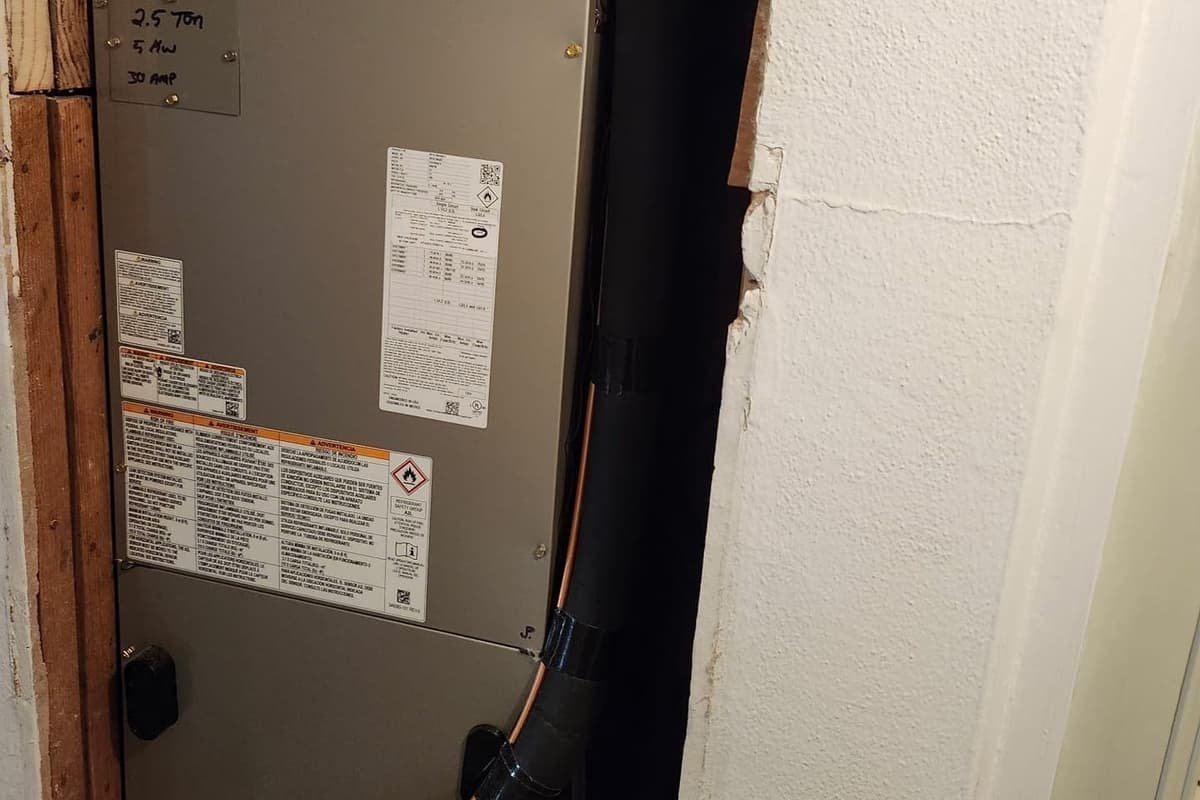 An indoor air handler with its rating labels in a closet.