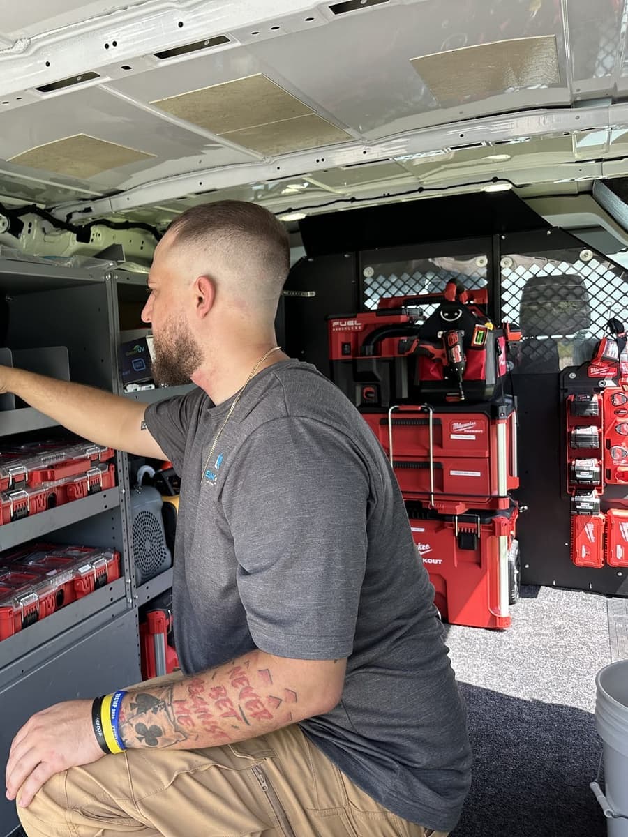 A SunCoast technician reaching for parts on the shelves inside the van in Spring Hill, FL.