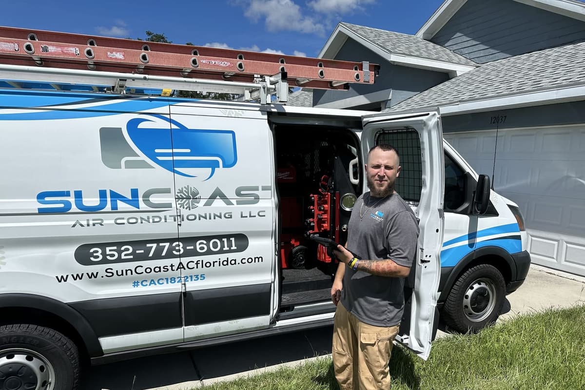 A SunCoast technician standing at the open van doors in Spring Hill, FL.