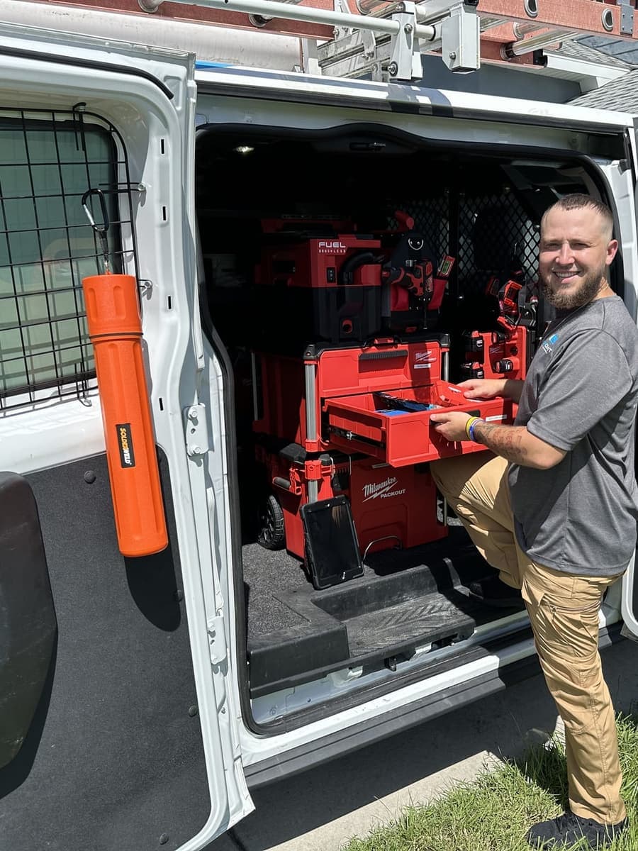 A SunCoast technician beside the van with its tool racks open in Spring Hill, FL.