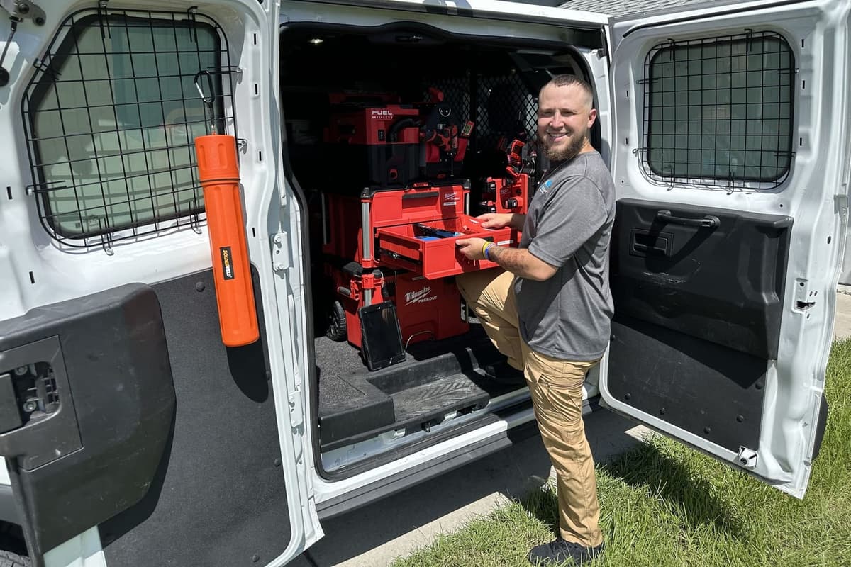 A SunCoast technician beside the van with its tool racks open in Spring Hill, FL.
