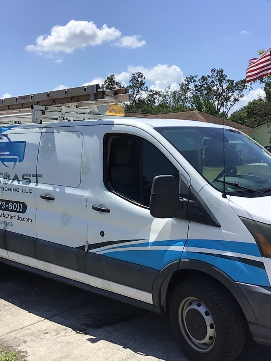 The SunCoast van parked in a driveway under an American flag.