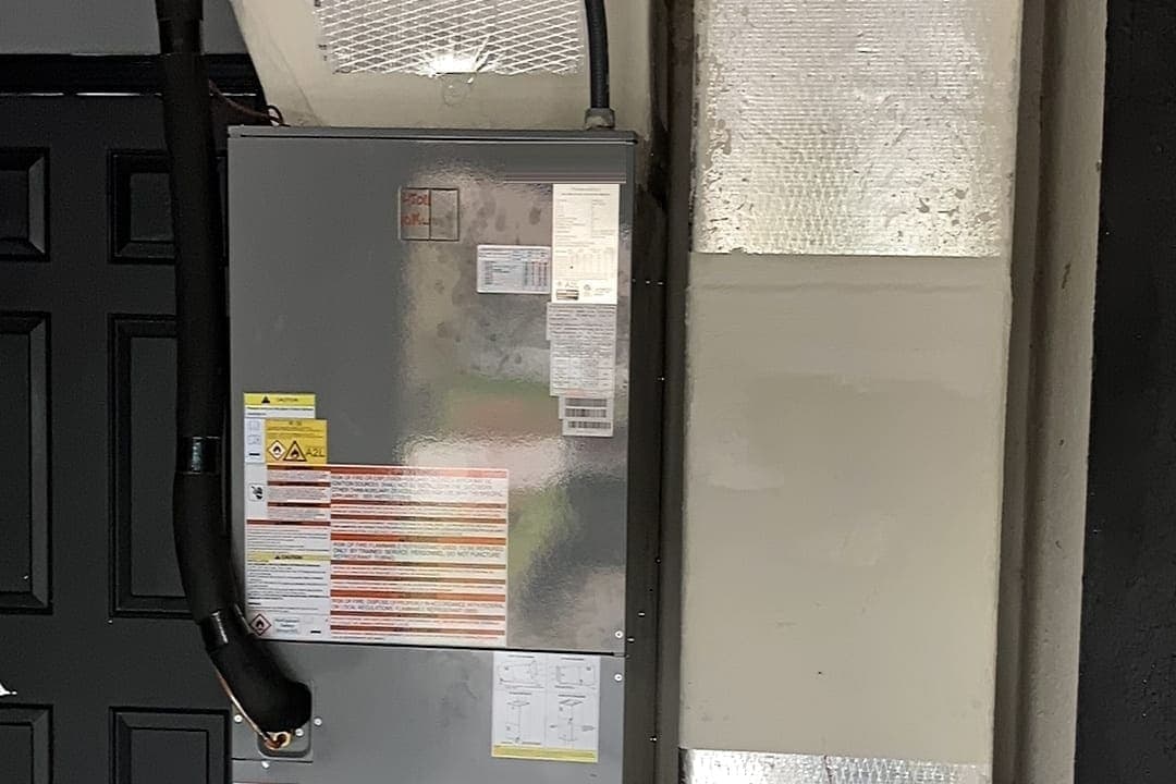 An air handler cabinet beside a dark door.