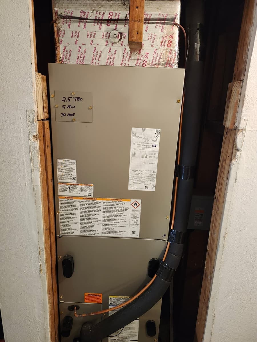 An air handler cabinet inside a framed closet.