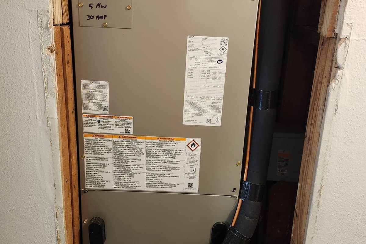 An air handler cabinet inside a framed closet.