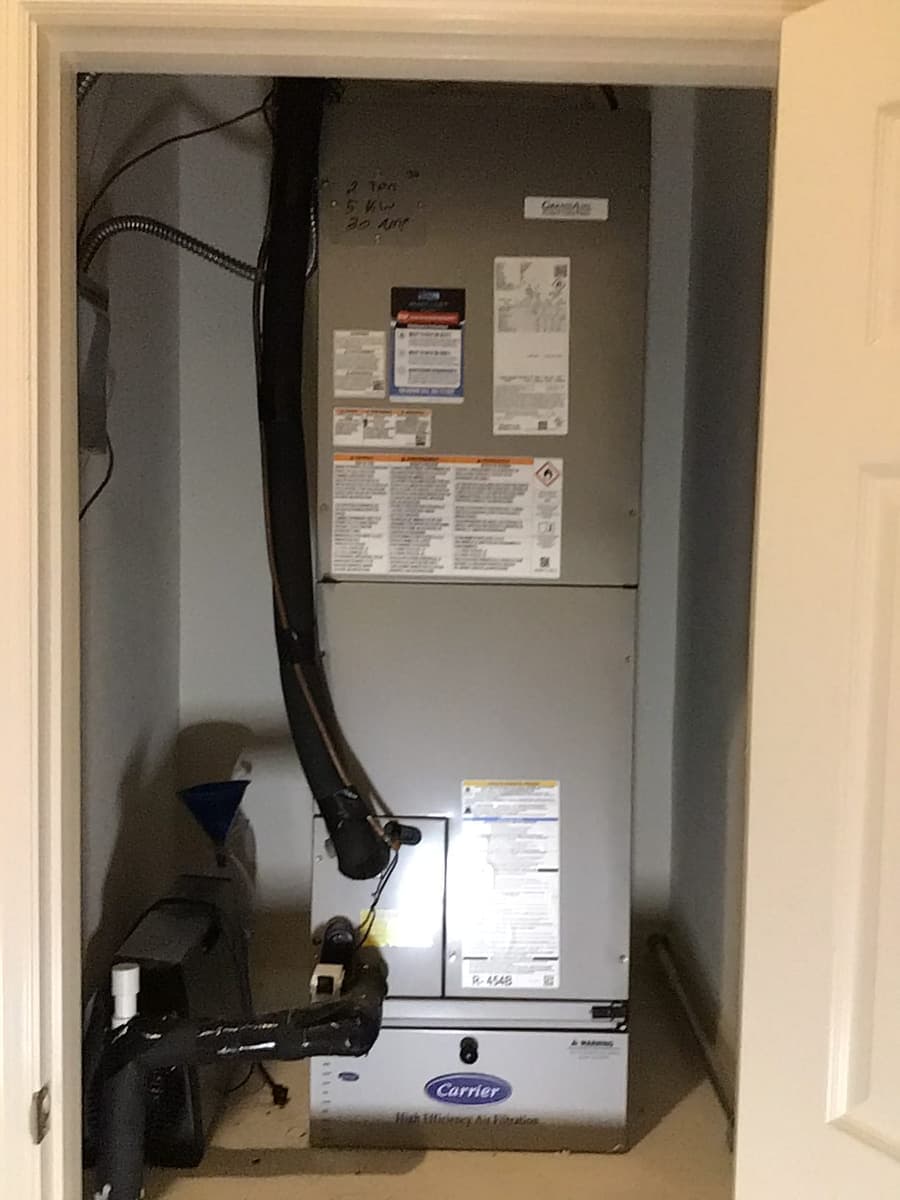 An air handler with its condensate drain and shut-off labels.