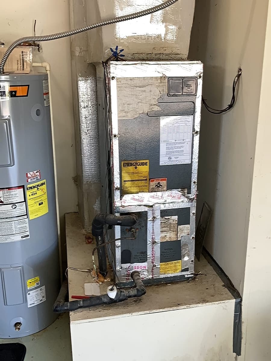 An air handler and water heater sharing a garage closet.
