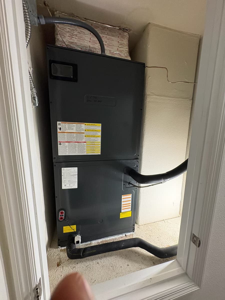 A black air handler cabinet with its drain line.