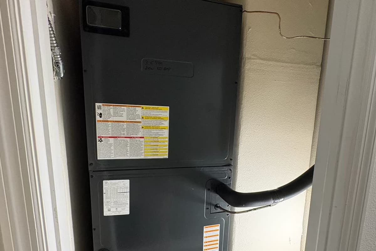 A black air handler cabinet with its drain line.