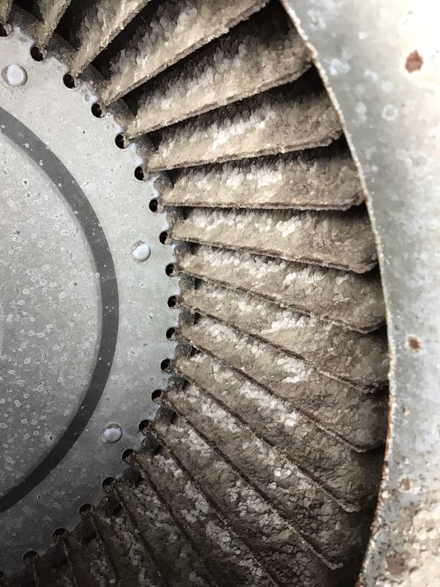 A blower wheel caked in dust.