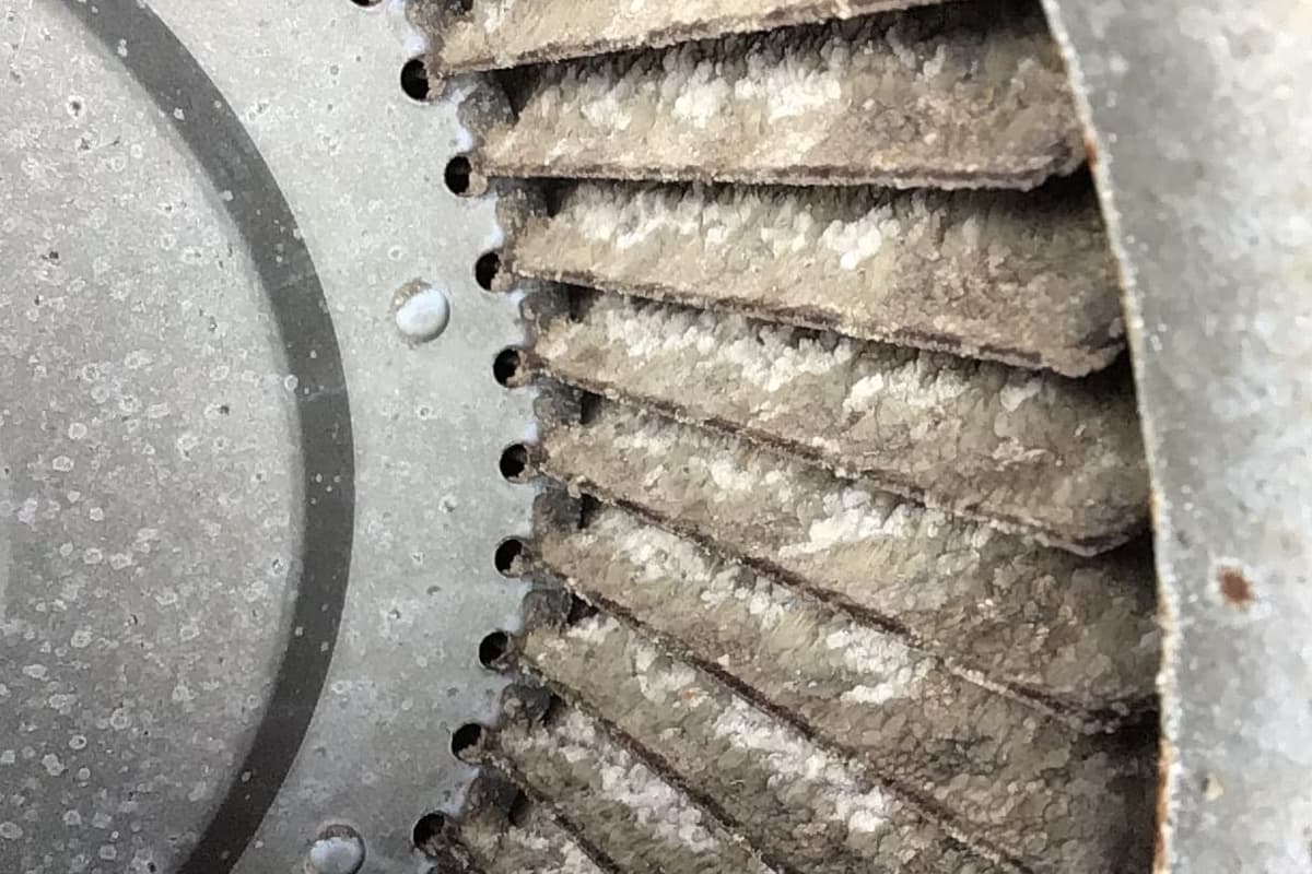 A blower wheel caked in dust.