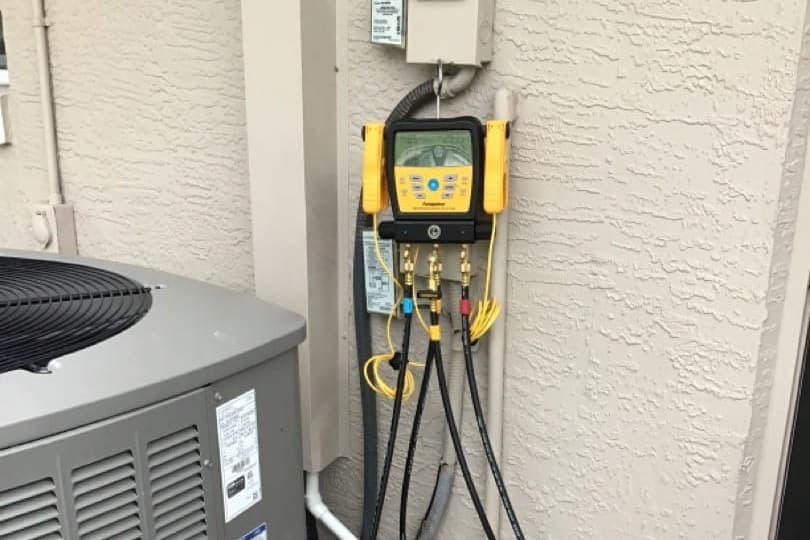 Gauge hoses and a manifold connected to an outdoor condenser.