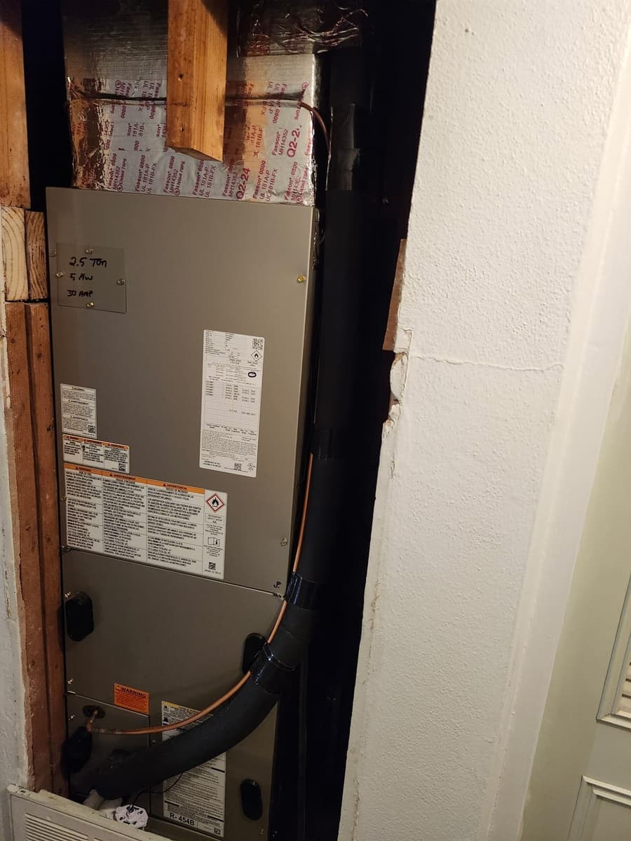 An indoor air handler with its rating labels in a closet.