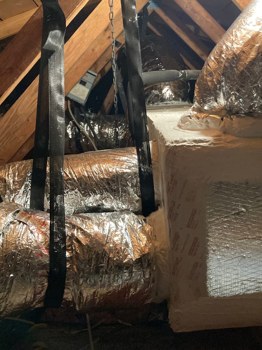 Insulated flexible duct running through an attic.
