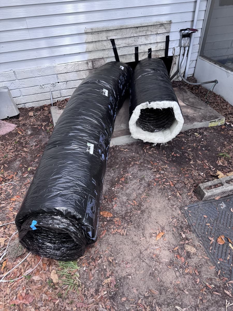 New insulated flex duct lying beside a house, ready to install in Hernando County, FL.
