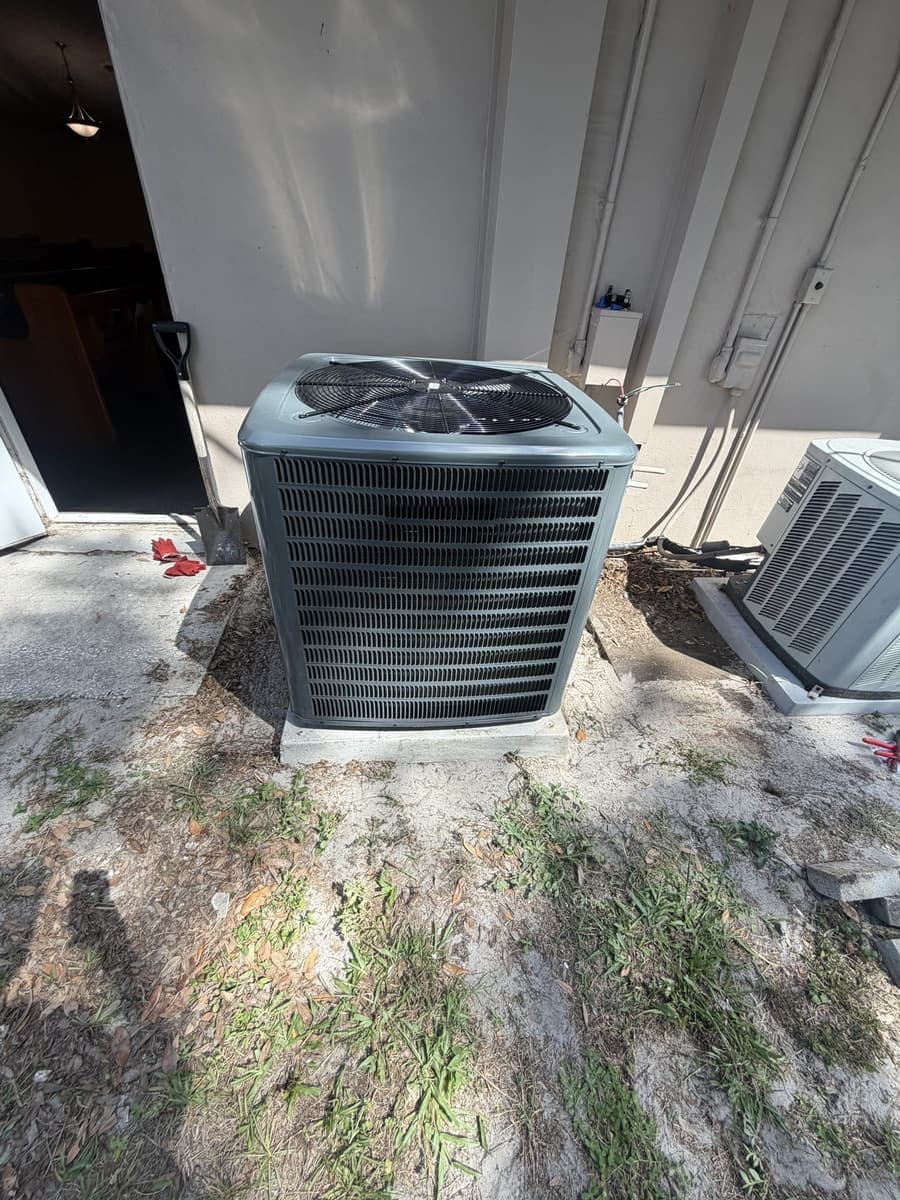 An outdoor condenser with its fan guard beside a second unit.