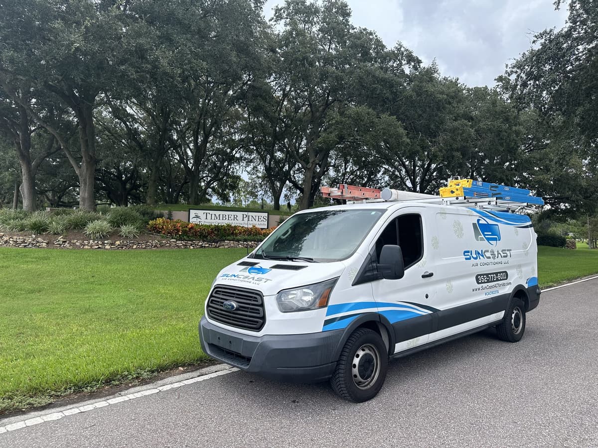 SunCoast Air Conditioning van parked beside the Timber Pines community entrance sign in Spring Hill, Florida