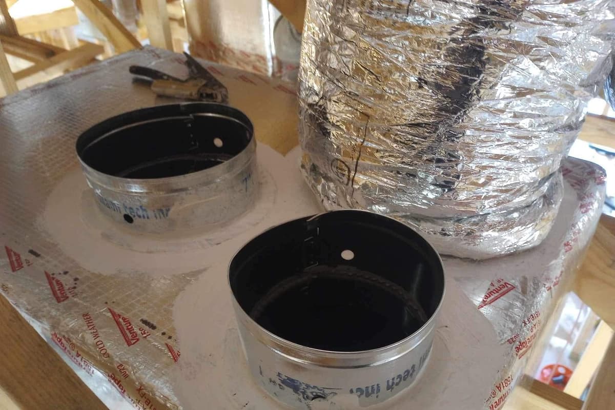 Sheet-metal collars on a plenum with flexible duct attached.