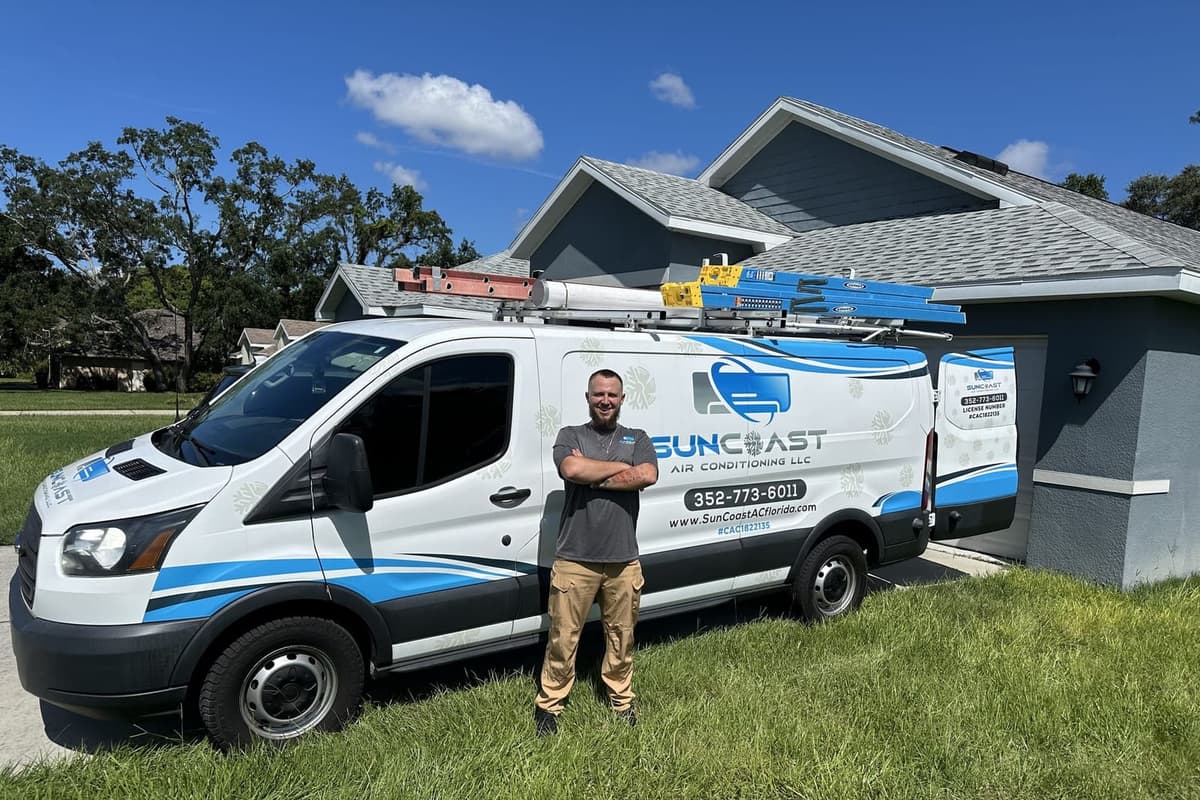 A SunCoast technician standing beside the branded service van.