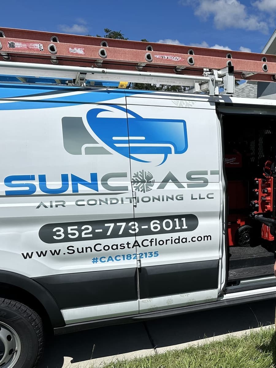 A SunCoast technician standing at the open van doors in Spring Hill, FL.