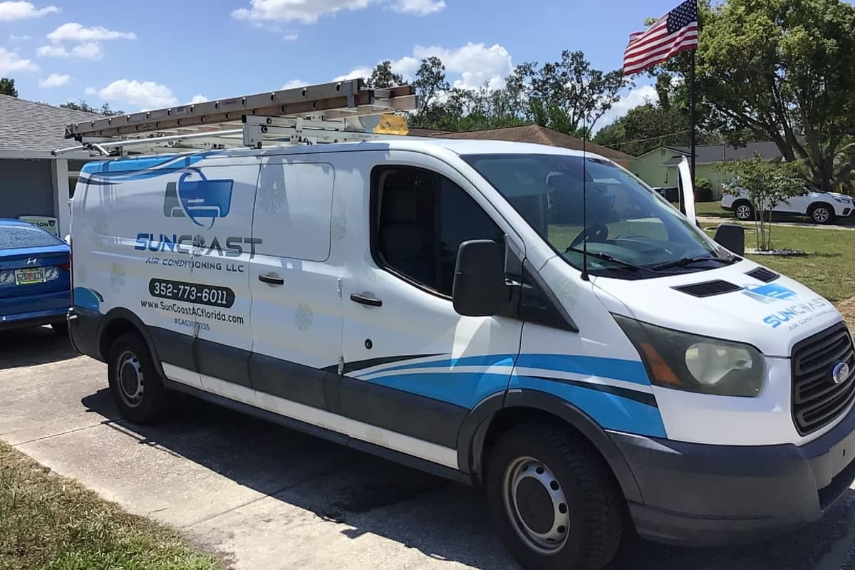 The SunCoast van parked in a driveway under an American flag.
