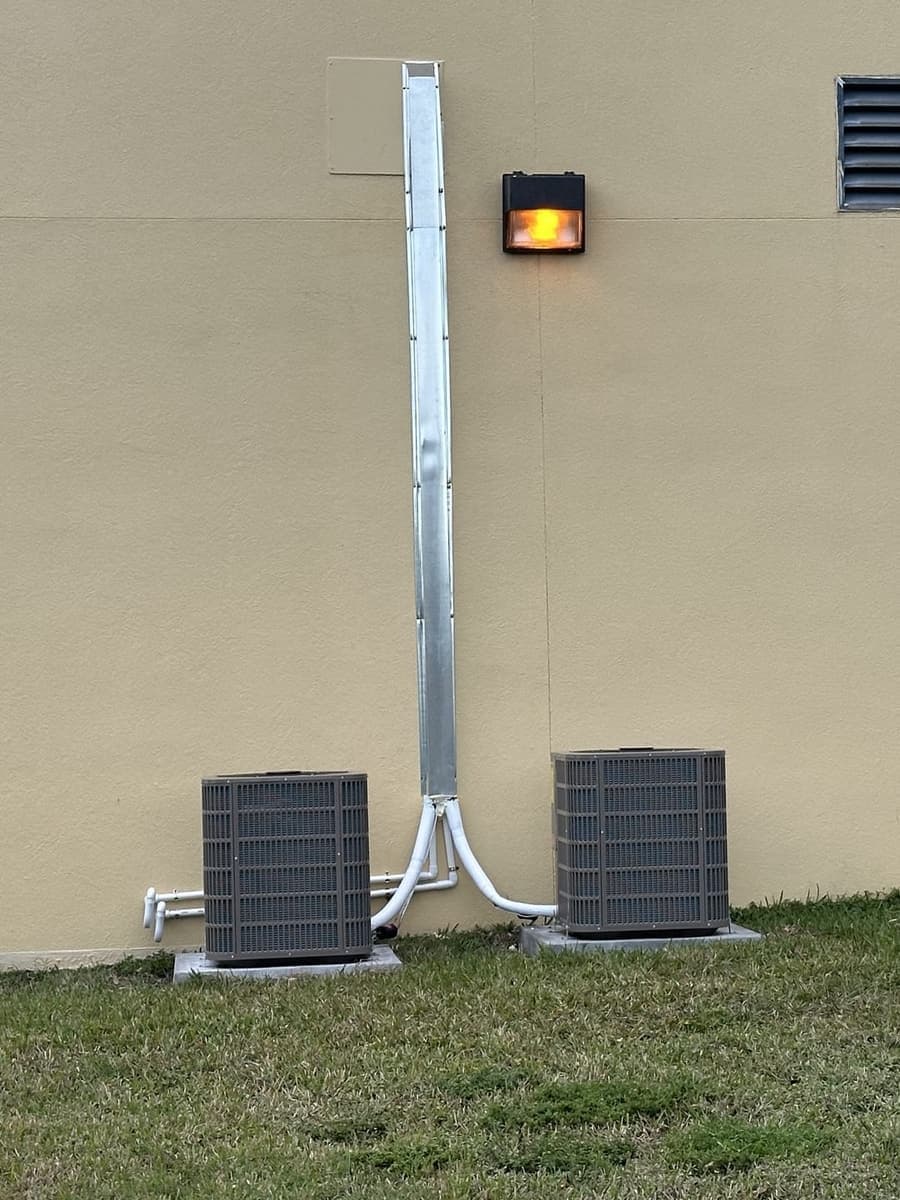 Two outdoor condensers at the base of a building wall in Hernando County, FL.