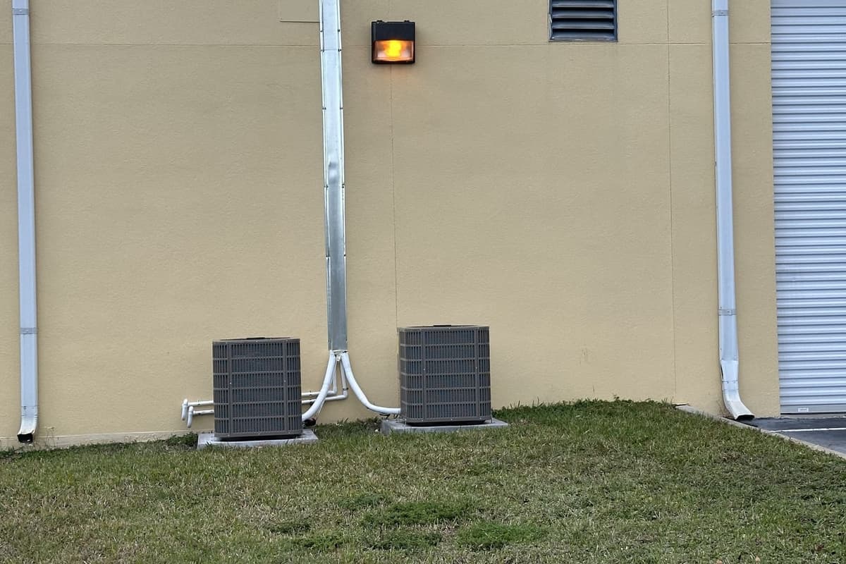 Two outdoor condensers at the base of a building wall in Hernando County, FL.