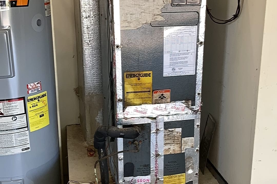 An air handler and water heater sharing a garage closet.