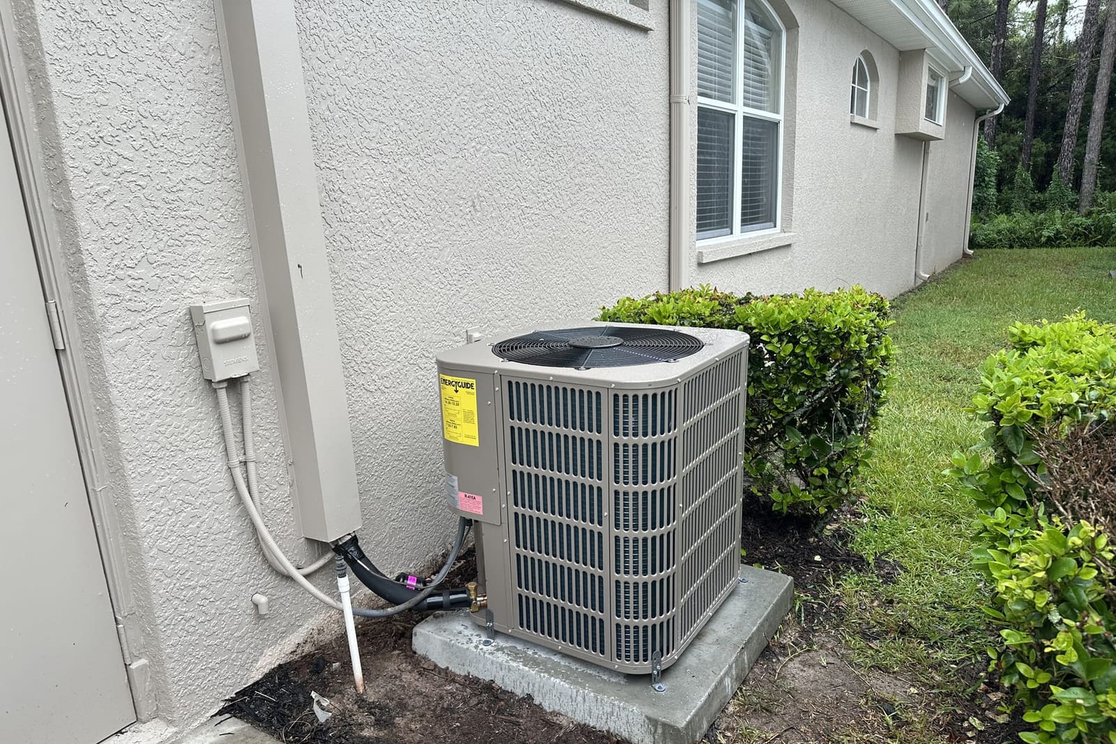 An outdoor condenser on a concrete pad beside a house in Hernando County, FL.
