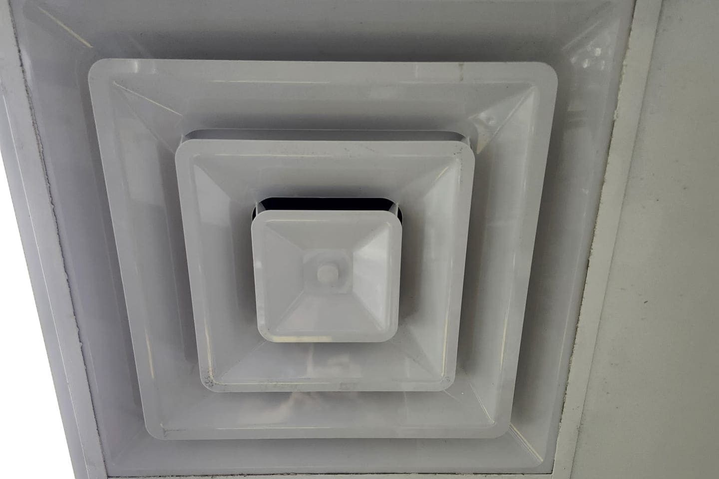 A square ceiling diffuser with a dirty perimeter.
